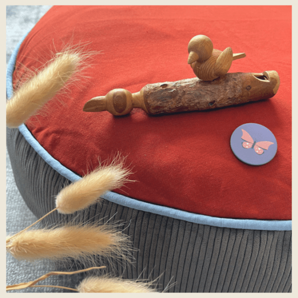 Stillkissenbezug von hey.lumico mit Vogelpfeifchen und Gräsern dekoriert